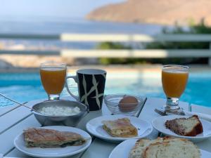 una mesa cubierta con platos de comida y dos bebidas en Yperia Hotel en Aegiali