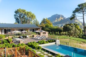 a home with a swimming pool and a house with a mountain at De Zeven in Stellenbosch