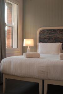 a bedroom with a bed with a lamp and a window at Hotel Isaacs Cork City in Cork