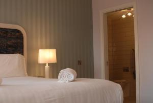 a bedroom with a white bed and a lamp at Hotel Isaacs Cork City in Cork
