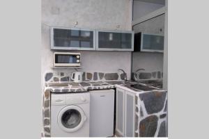 a kitchen with a washing machine and a microwave at Romantic Tenerife in Güimar