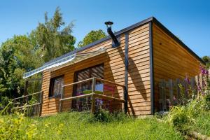 a small wooden cabin in a field of grass at chalet 2 personnes in Mialanes