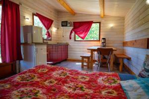 a bedroom with a bed and a kitchen with a table at chalet 2 personnes in Mialanes