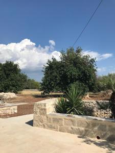 un mur en pierre avec quelques plantes dans une cour dans l'établissement Borgo delle Stelle, à Scicli