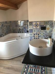 a large white tub in a bathroom with tiles at Borgo delle Stelle in Scicli