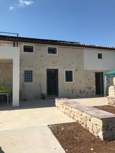 un mur en pierre devant un bâtiment dans l'établissement Borgo delle Stelle, à Scicli