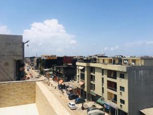 uitzicht op een straat met gebouwen en auto's bij Résidence Comara in Marcory