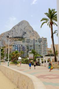 pessoas andando na praia com uma montanha ao fundo em Mesana 102 / Penthouse em Calpe