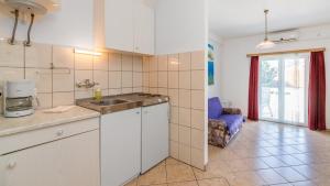 eine Küche mit einem Waschbecken und einem Sofa in einem Zimmer in der Unterkunft Damir & Gordana in Baška