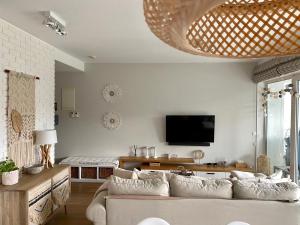 ein Wohnzimmer mit einem Sofa und einem TV in der Unterkunft Boho Natural Apartament Playa Baltis in Misdroy