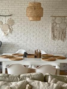 a white table with chairs and a white brick wall at Boho Natural Apartament Playa Baltis in Międzyzdroje