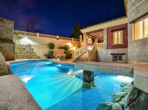a swimming pool in the backyard of a house at night at Villa Alhambra - Plusholidays in Calpe