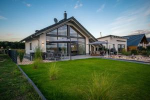 a large house with an open yard with a grassy field at Mein Beach House in Löbnitz