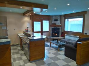 a kitchen and living room with a stove and a couch at Apartamentos Goizeder in Espinal-Auzperri