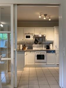 a kitchen with white cabinets and a stove top oven at Haus Jenny Wohnung E1 mit Terrasse in Boltenhagen