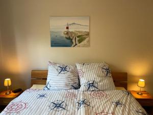 a bedroom with a bed and two lamps and a lighthouse at Haus Jenny Wohnung E1 mit Terrasse in Boltenhagen