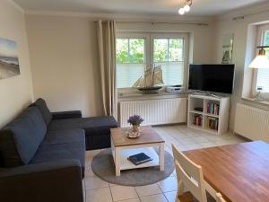 ein Wohnzimmer mit einem Sofa und einem Tisch in der Unterkunft Haus Jenny Wohnung E1 mit Terrasse in Boltenhagen