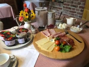 a table with a plate of food with meat and cheese at Heuhof-Breitau Gästezimmer in Sontra