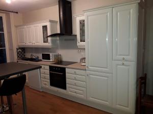 a kitchen with white cabinets and a stove top oven at Appartement 80m2 dans belle demeure in Vrigne-aux-Bois