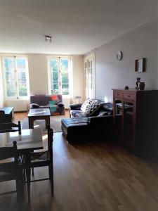 uma sala de estar com um sofá e uma mesa em Appartement 80m2 dans belle demeure em Vrigne-aux-Bois