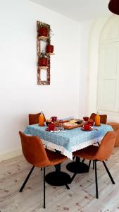 a dining room table with a blue table cloth and chairs at Cork Train Station Guesthouse in Esmoriz
