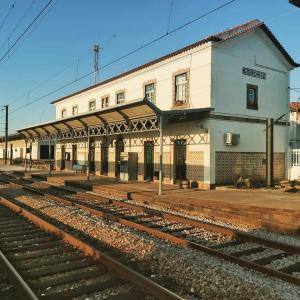 a train station with a train track and a building at Cork Train Station Guesthouse in Esmoriz
