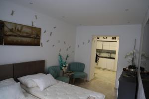ein Schlafzimmer mit einem Bett und zwei blauen Stühlen in der Unterkunft Love Nest apartment in Ljubljana