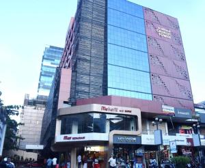 a tall building with a store in front of it at Alhind Calicut Tower in Kozhikode