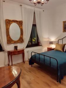 een slaapkamer met een bed, een spiegel en een tafel bij Apartment lux gimnazjalna in Bydgoszcz