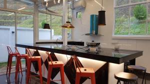 a kitchen with a counter with chairs around it at Rose Hill Gardens in Brinchang
