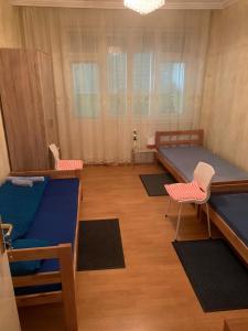 Habitación con 1 cama y 2 sillas. en Apartman Pejica, en Čačak