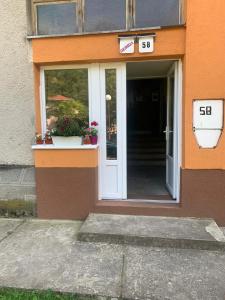 uma porta da frente de um edifício com um sinal nele em Apartman Pejica em Čačak