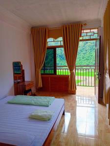 a bedroom with a bed and a large window at Ba Be Lake View Homestay in An Ma