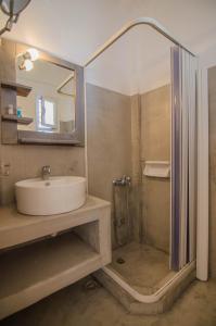 uma casa de banho com um lavatório e um chuveiro em Skala Sunset Hotel and spa em Ios Chora