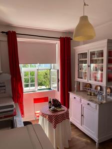 a kitchen with red curtains and a table in it at Casa Morgado do Casco in Estremoz