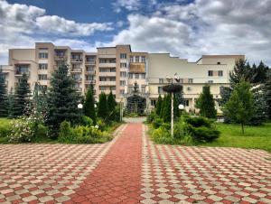 un gran edificio con un camino de ladrillo rojo delante de él en Olimp park-hotel Kolomna, en Kolomna