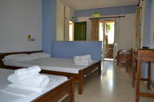 a room with two beds and a mirror at Tilegrafos Studios in Lefkada