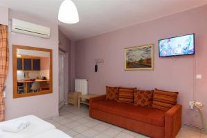 a living room with a couch and a tv on the wall at Ktima Anastasia Green Stay Nafplio in Nafplio