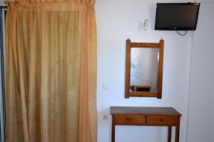 a mirror and a dresser in a room with a curtain at Tilegrafos Studios in Lefkada