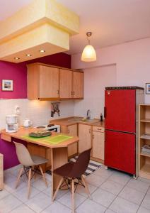 a kitchen with a red refrigerator and a table with chairs at Ktima Anastasia Green Stay Nafplio in Nafplio