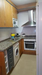 a kitchen with a stove and a sink and a dishwasher at TU CASA EN MEQUINENZA CON WIFI in Mequinenza