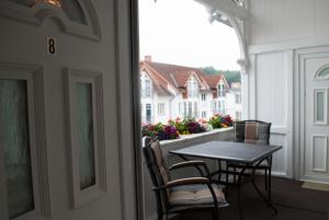 einen Tisch und Stühle auf einem Balkon mit Fenster in der Unterkunft Villa Anna in Ostseebad Sellin