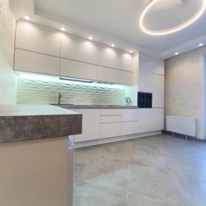 a large kitchen with white cabinets and a counter at Rent Vip apartment in Kyiv in Kyiv