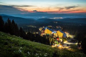 a view of a town in the mountains at night at TES Flora Apartments in Borovets