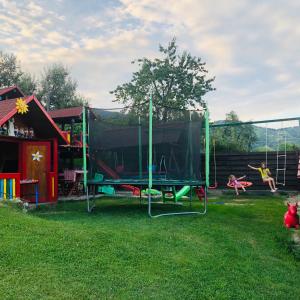 a playground with a trampoline in the grass at Pensiunea Dorali in Moieciu de Jos