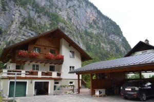 a house with flowers on the balcony in front of a mountain at Ferienwohnung Zauner in Hallstatt