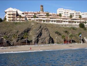 Blick auf einen Strand mit Gebäuden im Hintergrund in der Unterkunft Apartamentos Torreon Del Mar in Benalmádena