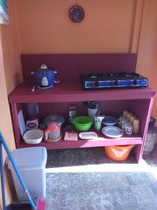 a red shelf with dishes and other items on it at Hotel One Love Puerto Viejo in Puerto Viejo