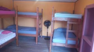 a room with four bunk beds and a lamp at Hotel One Love Puerto Viejo in Puerto Viejo
