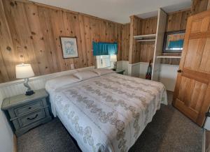 um quarto com uma cama e uma parede de madeira em Outer Banks Motel - Village Accommodations em Buxton